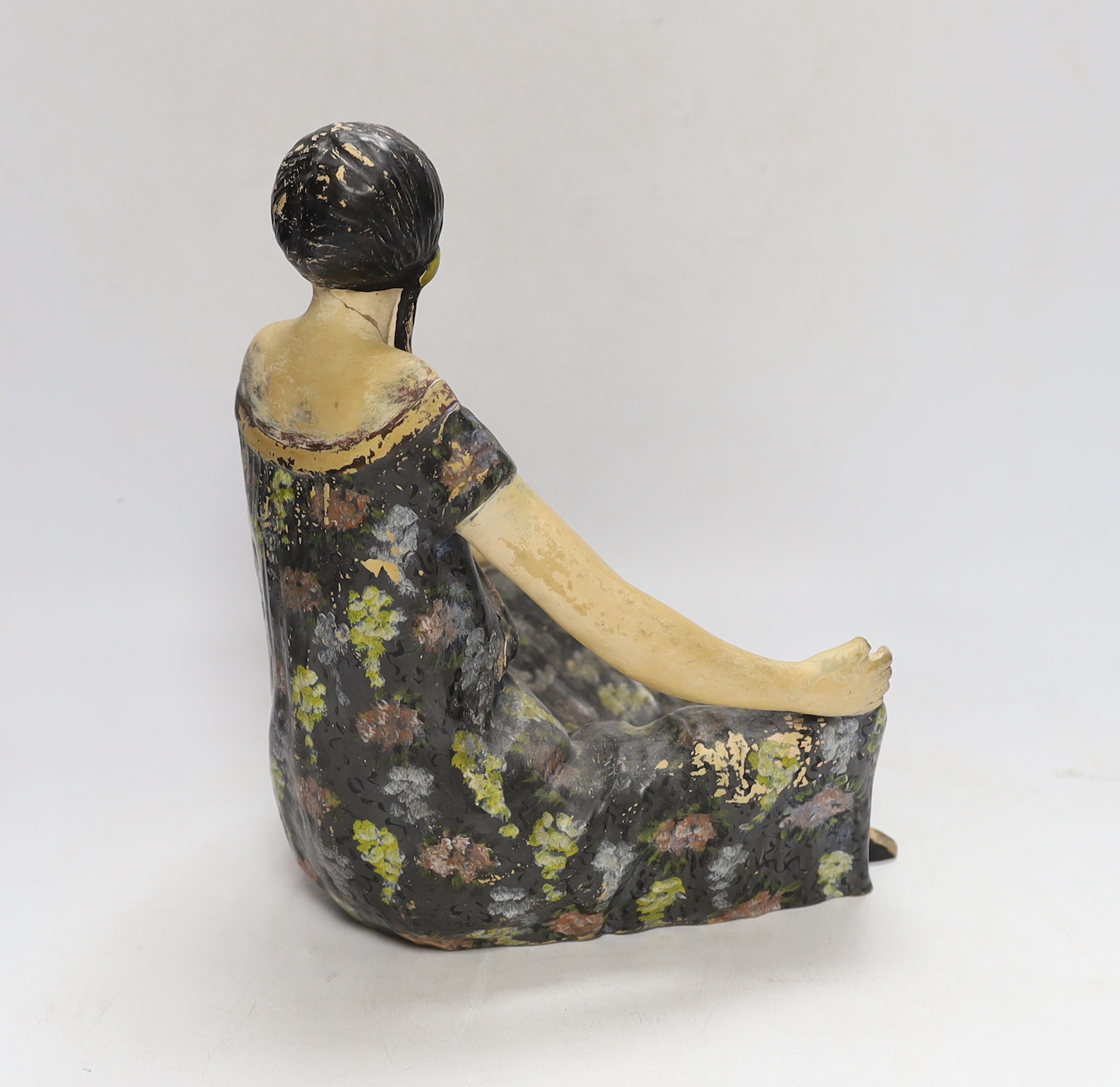 An Austrian painted terracotta figure of a seated girl, 27cm high